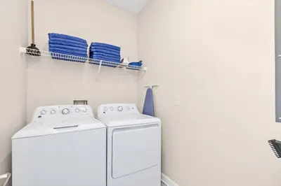 a white laundry room with a washer and dryer at Delight Indoor Adventure Steps From Disney in Kissimmee