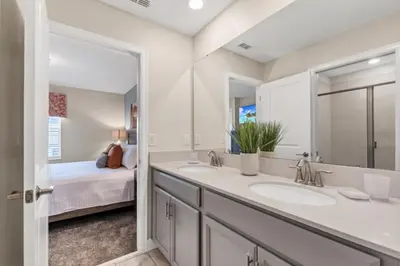 a bathroom with two sinks and a bedroom at Delight Indoor Adventure Steps From Disney in Kissimmee