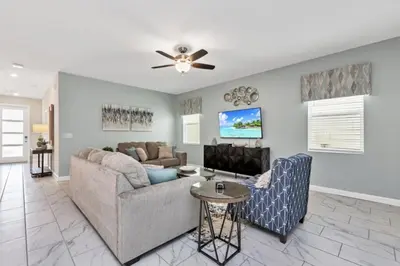 a living room with a couch and a table at Delight Indoor Adventure Steps From Disney in Kissimmee