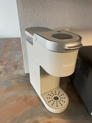 a coffee maker sitting on a stand next to a wall at Lovely 1 bedroom Condo with pool in Orlando