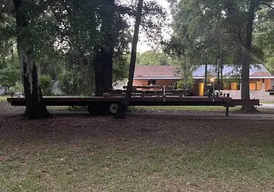 a flat bed truck parked in front of trees at The Piano House in Orlando