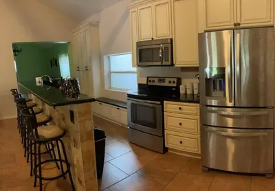 a kitchen with a stainless steel refrigerator and a counter at The Piano House in Orlando