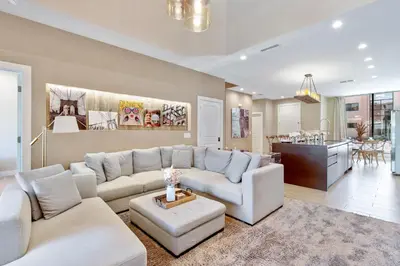 a living room with white furniture and a kitchen at Cozy Home Resort Community Disney 5 Min in Orlando