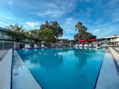 a large swimming pool with chairs and umbrellas at Baymont by Wyndham Orlando Lake Buena Vista South in Kissimmee