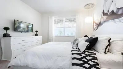 a white bedroom with a bed and a dresser at Elegant Fun Vacation Home at Encore Resort 7529 in Orlando