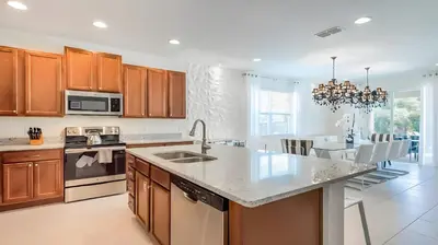 a kitchen with wooden cabinets and a large kitchen island at Elegant Fun Vacation Home at Encore Resort 7529 in Orlando