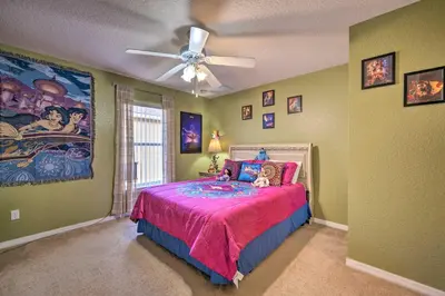a bedroom with a bed with a ceiling fan at 10 Mi to Disney and Heated Pool Florida Abode! in Orlando