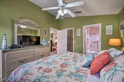 a bedroom with a bed and a dresser with a mirror at 10 Mi to Disney and Heated Pool Florida Abode! in Orlando