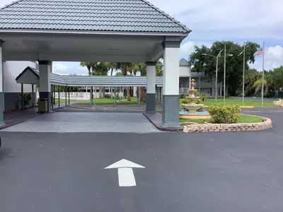 a white arrow in a parking lot with a building at Heritage Park Inn in Kissimmee