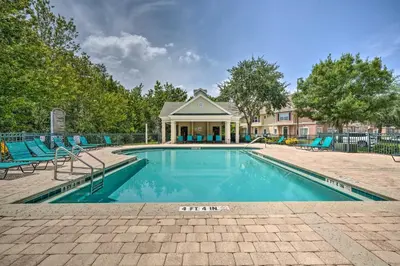 a swimming pool with chairs and a house at Kissimmee Condo Community Perks, 10 Mi to Disney! in Kissimmee