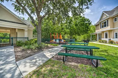 a park with two picnic tables and a playground at Kissimmee Condo Community Perks, 10 Mi to Disney! in Kissimmee