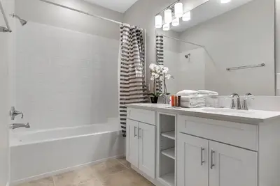 a white bathroom with a tub and a sink and a bath tub at 2 Bedrooms 2 Bathrooms Storey Lake 3150-404 Pc in Kissimmee