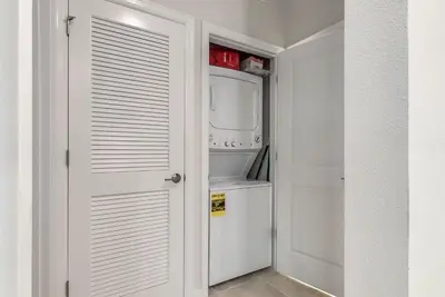 a white closet with a washer and dryer at 2 Bedrooms 2 Bathrooms Storey Lake 3150-404 Pc in Kissimmee