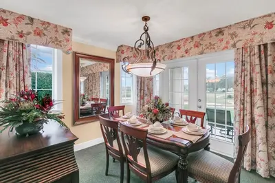 a dining room with a table and chairs and windows at 3 Bedrooms 25 Bathrooms Reunion Resort 1589 Hc in Orlando