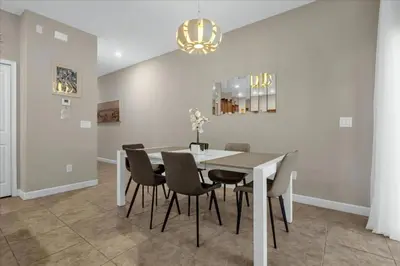 a dining room with a table and chairs at 4 Bedrooms 3 Bathrooms Storey Lake 3195 Pp in Orlando
