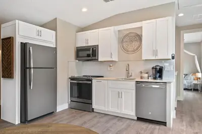 a kitchen with white cabinets and stainless steel appliances at Bohemian Retreat in the Heart of Orlando in Orlando