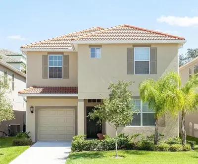 a house with a garage and palm trees at Marvelous Magical House: Amazing Themes and Pool, 5mi Disney in Kissimmee