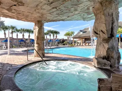 a swimming pool at a resort with a rock structure at Marvelous Magical House: Amazing Themes and Pool, 5mi Disney in Kissimmee