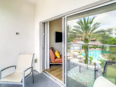 a room with a balcony with a view of a pool at Pet Friendly in Orlando area near Disney in Orlando