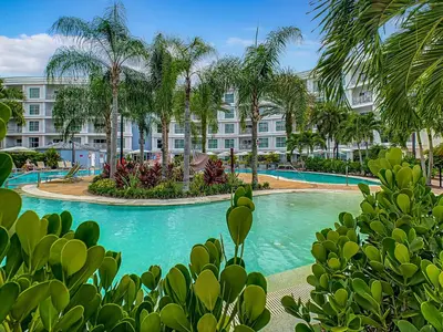 a resort pool with palm trees and a building at Pet Friendly in Orlando area near Disney in Orlando