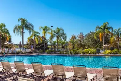 a pool with chairs and palm trees at 3 Bed Penthouse Near Convention Center! condo in Orlando