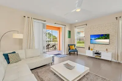 a living room with a white couch and a tv at 1511RETREAT townhouse in Orlando