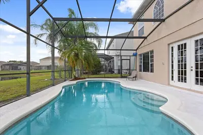 a swimming pool in front of a building at LONG STAYS! Lakefront - Gated Pool Home in Orlando