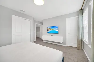 a bedroom with a bed and a tv on the wall at 8 Bedroom 6 Bathroom Resort Home villa in Kissimmee