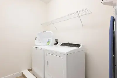 a white laundry room with a washer and dryer at Alluring Home With Private Pool Near Disney With Waterpark Resort Access At Encore Resort - 7732Ff in Kissimmee
