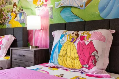 a bedroom with a bed with a disney princess pillow at Disney Area 4BR Home with Heated Private Pool in Kissimmee