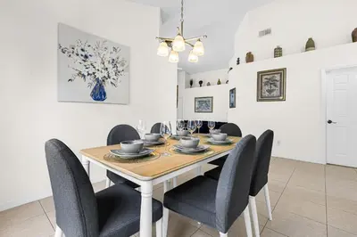 a dining room with a wooden table and chairs at Disney Area 4BR Home with Heated Private Pool in Kissimmee