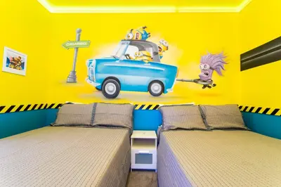 a bedroom with two beds with a cartoon car on the wall at Magnificent 5Bd w/ Pool Close to Disney @Storey Lake 4800 in Kissimmee