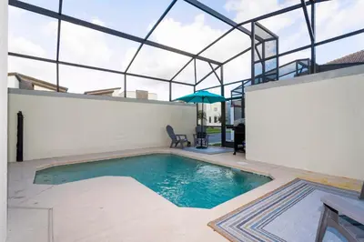 an indoor swimming pool with a glass roof at Magnificent 5Bd w/ Pool Close to Disney @Storey Lake 4800 in Kissimmee