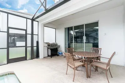 a patio with a table and chairs and a piano at Blue Moon House in Kissimmee