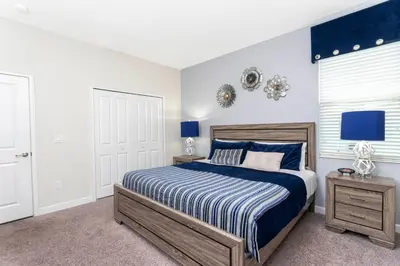 a bedroom with a blue and white bed and a window at Blue Moon House in Kissimmee