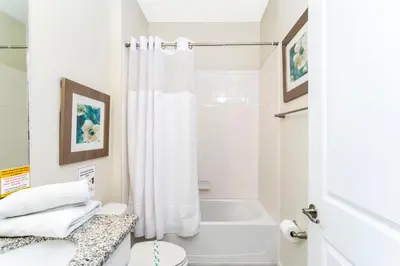 a white bathroom with a tub and a toilet at Blue Moon House in Kissimmee