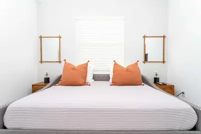 a bedroom with a large bed with orange pillows at Gorgeous 2Bd Apto Close to Disney @ Storey Lake 404 3191 in Kissimmee