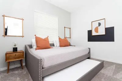 a bedroom with a bed with orange pillows at Gorgeous 2Bd Apto Close to Disney @ Storey Lake 404 3191 in Kissimmee