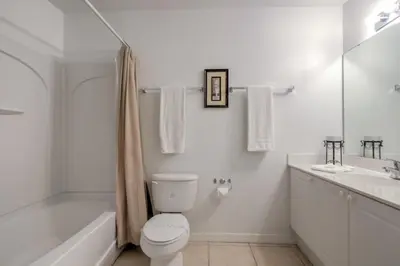 a white bathroom with a toilet and a tub and a sink at Club Cortile 3 Bedroom Condo Resort Pool 8 Miles to Disney in Kissimmee
