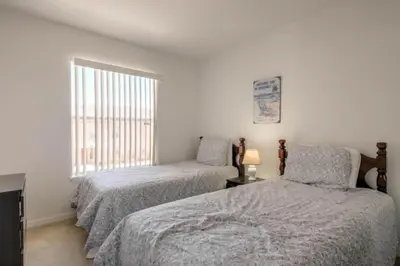 a bedroom with two beds and a window at Club Cortile 3 Bedroom Condo Resort Pool 8 Miles to Disney in Kissimmee