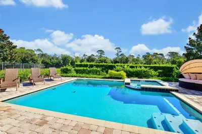 a swimming pool with chairs and a swimming pool at Spectacular Home Near Disney With Private Pool And Waterpark & Resort Access At Encore Resorts Reunion - 7523Mr in Kissimmee