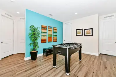 a room with a ping pong table in front of a wall at Spectacular Home Near Disney With Private Pool And Waterpark & Resort Access At Encore Resorts Reunion - 7523Mr in Kissimmee