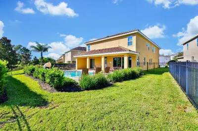 a house with a pool in a yard at Spectacular Home Near Disney With Private Pool And Waterpark & Resort Access At Encore Resorts Reunion - 7523Mr in Kissimmee