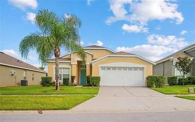 a house with a palm tree and a white garage at Vacation Resort Home Right Outside of Disney World Parks with Private Pool home in Kissimmee