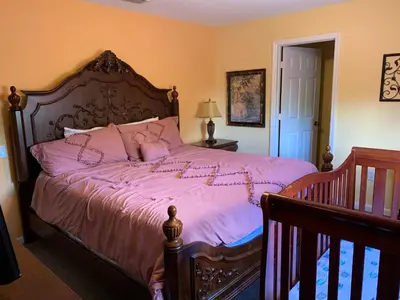a bedroom with a large bed with pink sheets at Windsor Hill Resort Home w Pool, 5 Min from Disney in Orlando