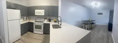 a kitchen with gray cabinets and a white refrigerator at Home sweet Home near Disneyland in Kissimmee