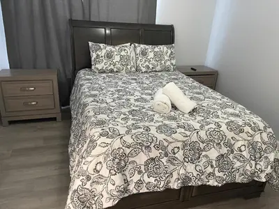 a bed with a black and white comforter and two towels at Home sweet Home near Disneyland in Kissimmee
