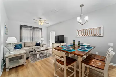 a dining room and living room with a table and chairs at Vista Cay Resort in Orlando
