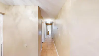 a hallway with white walls and a white ceiling at Pura Vida in Orlando