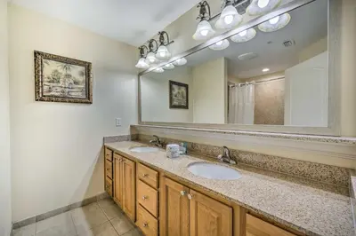 a bathroom with two sinks and a large mirror at 1 Mi to Disney Condo with Water-View Balcony! in Orlando